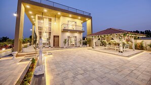 Un hotel moderno con un patio amplio, un área de estar cubierta al aire libre y un balcón.