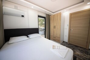A hotel room with a bed, a wardrobe, and an air conditioning unit. - Villa Berk SARIGERME (Sarıgerme)