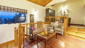 Uma sala de estar com piso de madeira, um sofá, uma mesa de centro e uma escada.