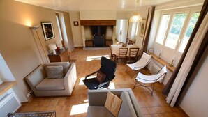 A living room with a sofa, armchairs, a dining table, and a fireplace. - Les Bardilles*Country house*3km from Sarlat (Sarlat-la-Canéda)