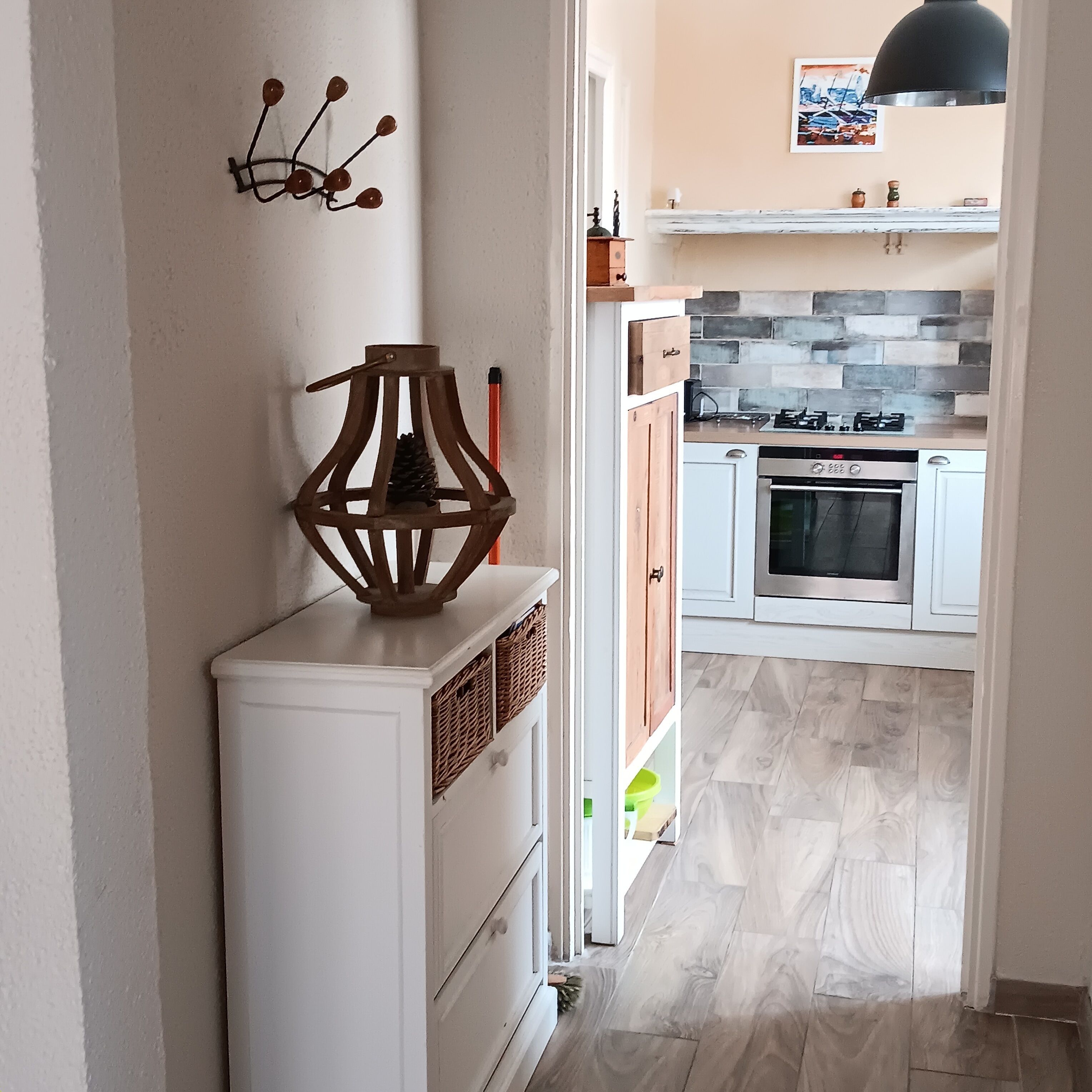 A modern kitchen with white cabinets, a gas stove, and a built-in oven.