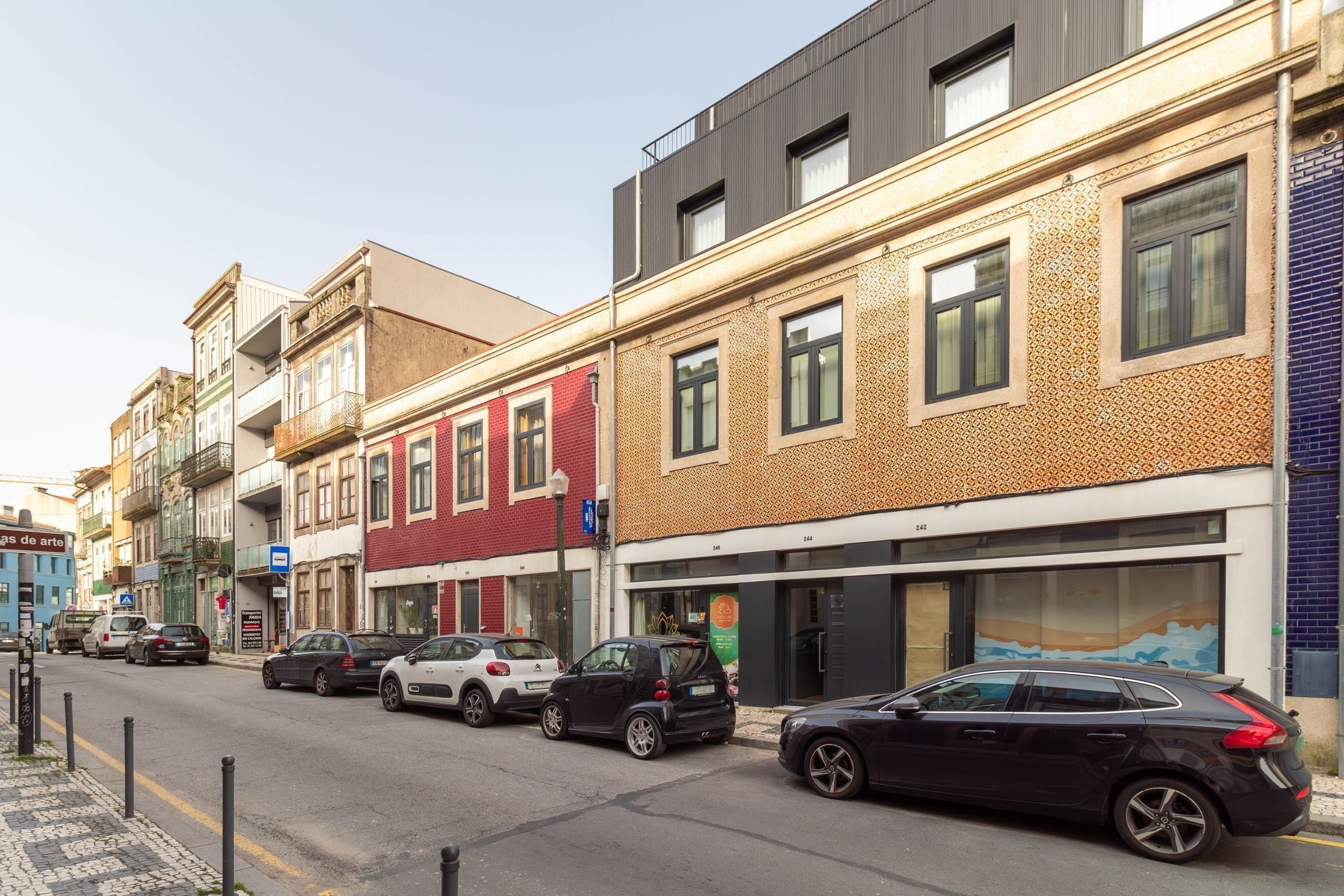 Una calle con coches aparcados y edificios de diversos estilos arquitectónicos.