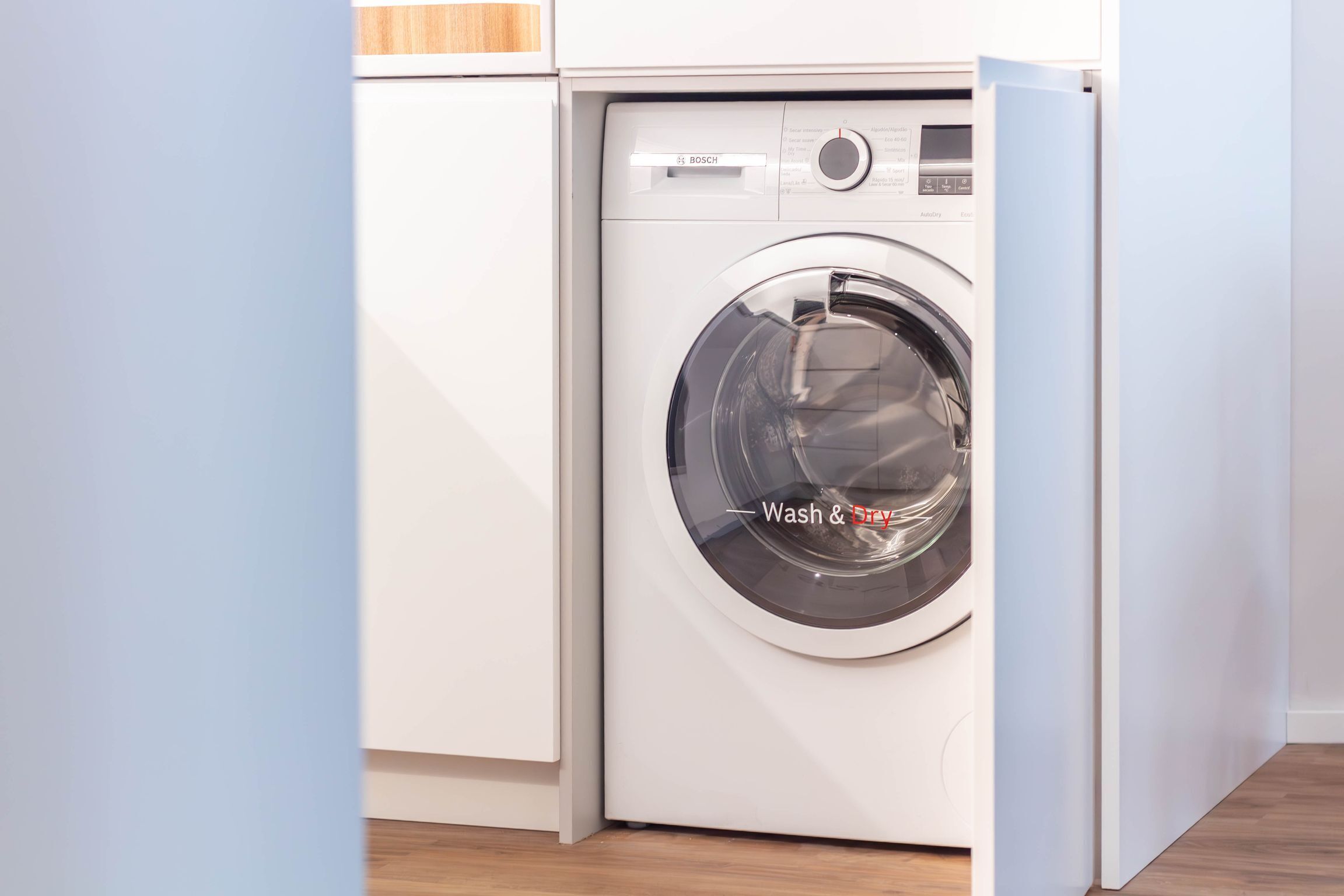 Una lavadora de carga frontal con un panel de control y una etiqueta que dice 'Wash & Dry'.