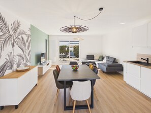 A modern kitchen with a dining area, a sofa, and a view to the outside. - 600m to the beach – House for 6 with veranda (Treffiagat)