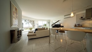 A modern living room with a sofa, chairs, a piano, and a fireplace. - House Ocean Front Arzon Port Navalo (Arzon)