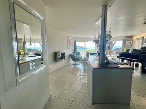A spacious living area with a piano, a fireplace, and a view of the sea. - House right on the beach in Arzon Port Navalo (Arzon)