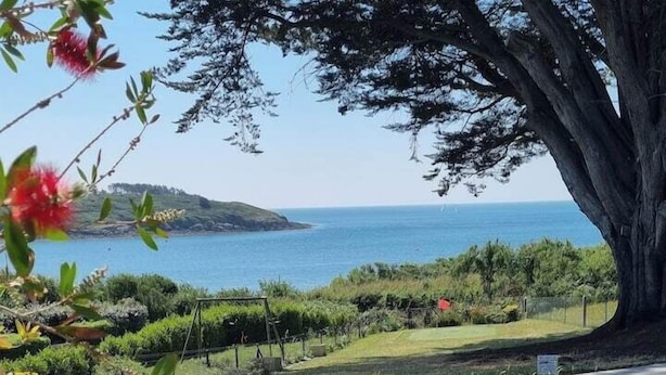 A patio with two lounge chairs, a grassy area, and a view of the sea. - House Ocean Front Arzon Port Navalo (Arzon)