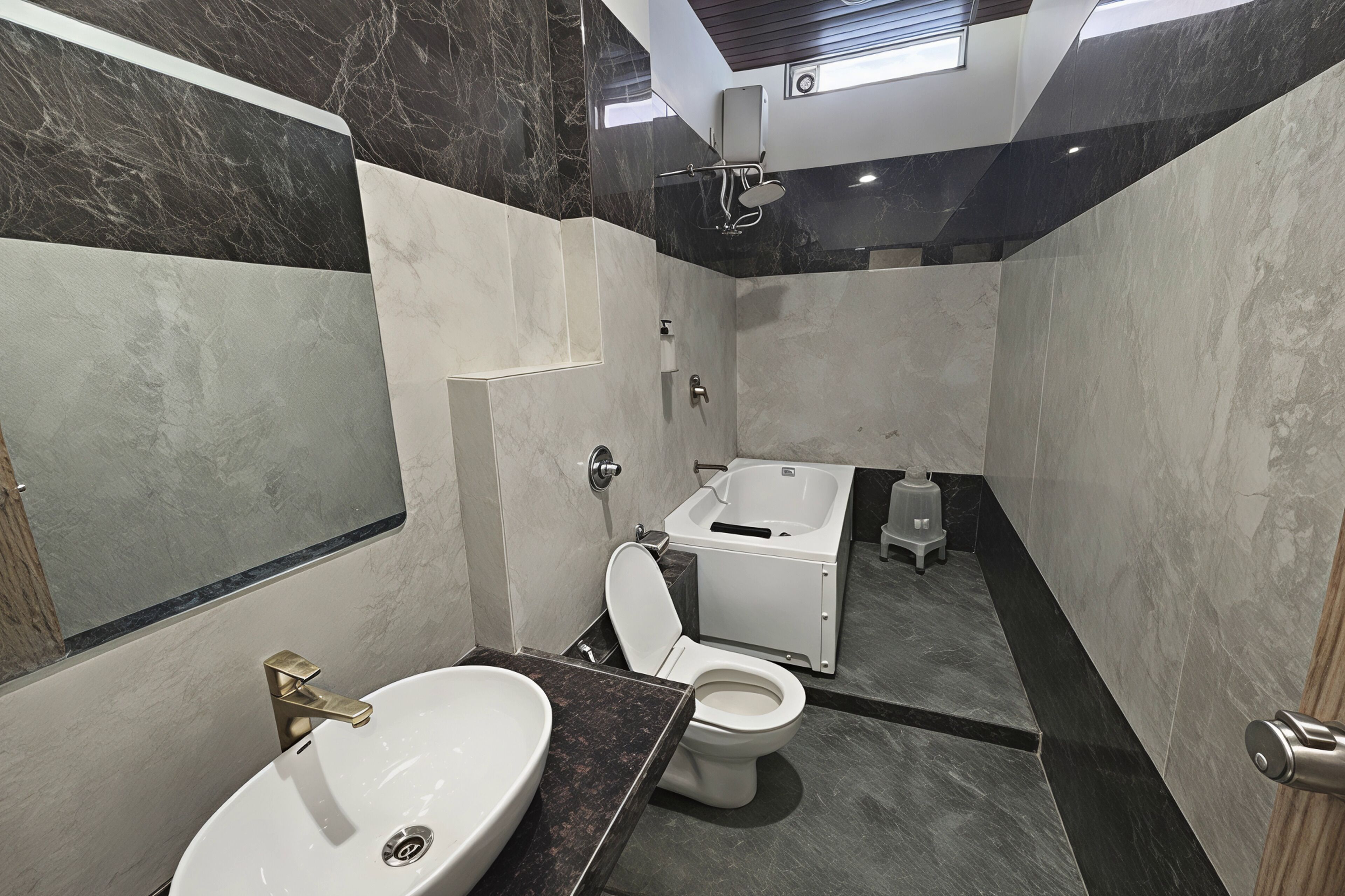 Een moderne badkamer met een wastafel, toilet en bad.