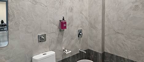 A modern bathroom with a toilet, bidet, and shower.
