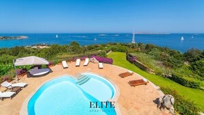 Area piscina con lettini e vista sul mare.
