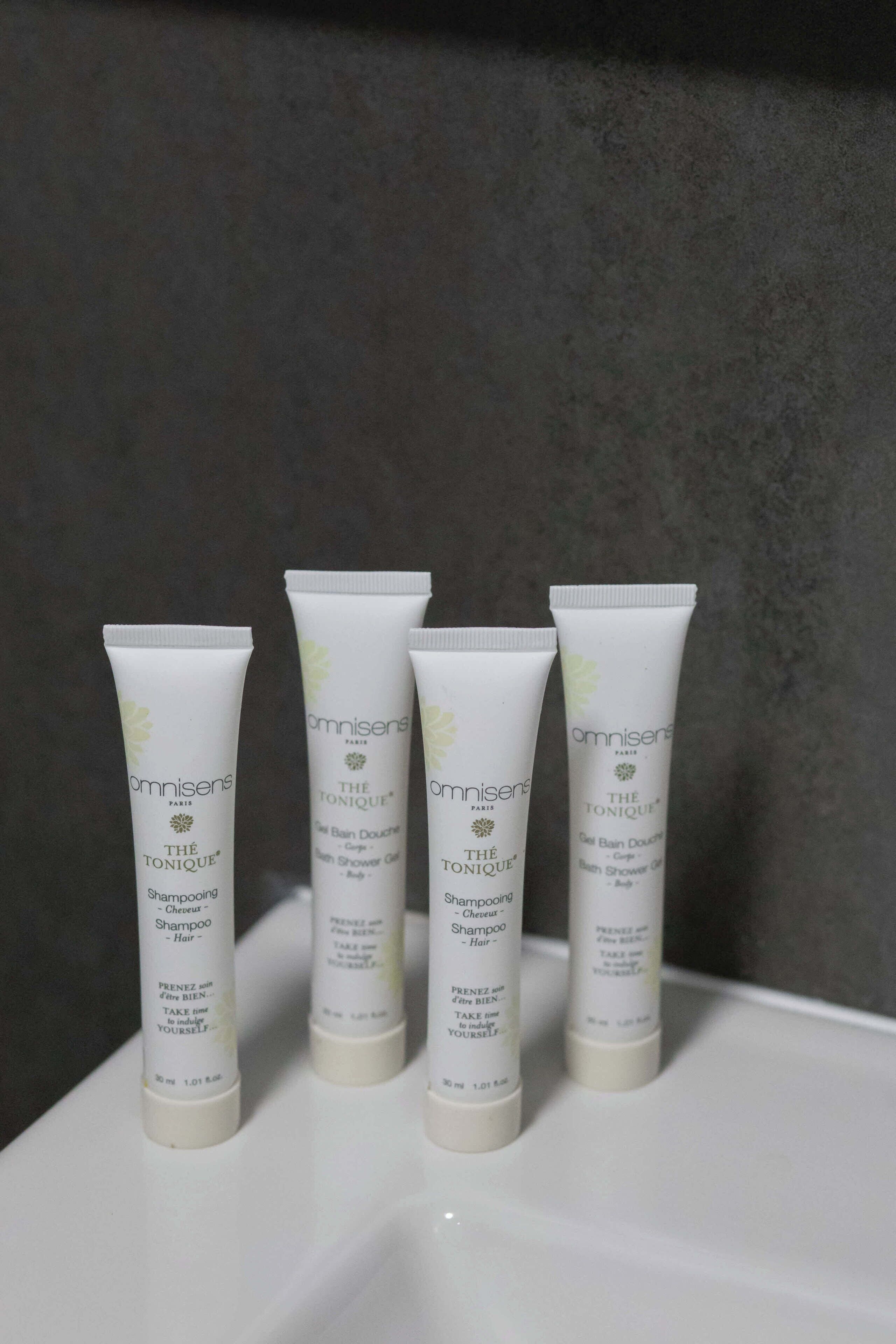 Four tubes of hair care product on a white surface.
