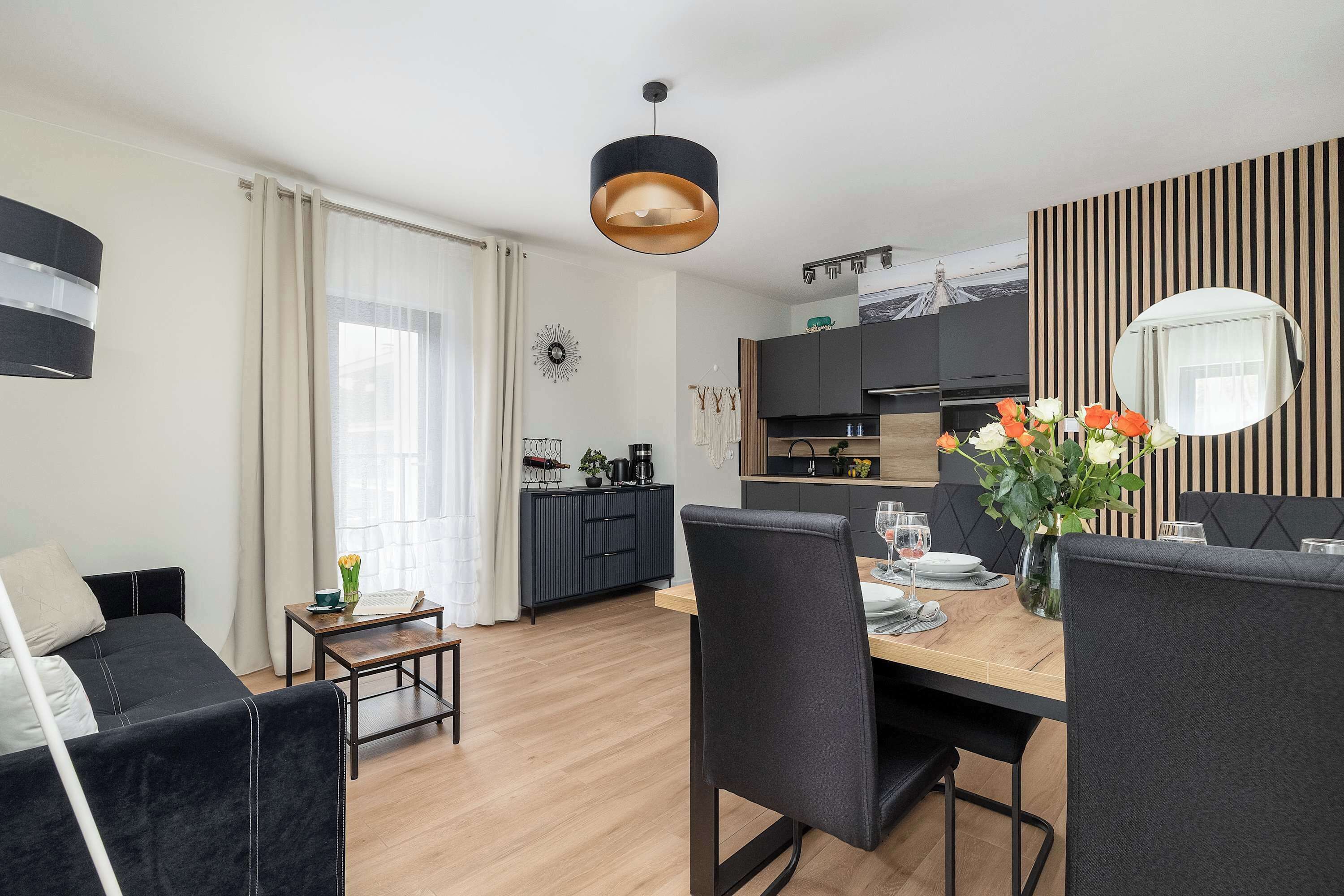 Ein modernes Wohnzimmer mit Essbereich, Küche und einer Couch.