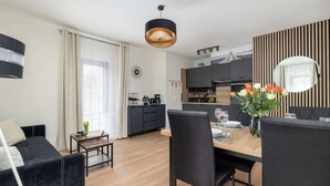 Een moderne leefruimte met een eethoek, keuken en een bank.