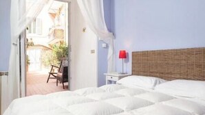 Quarto com cama grande, teto de madeira e vista para o exterior.