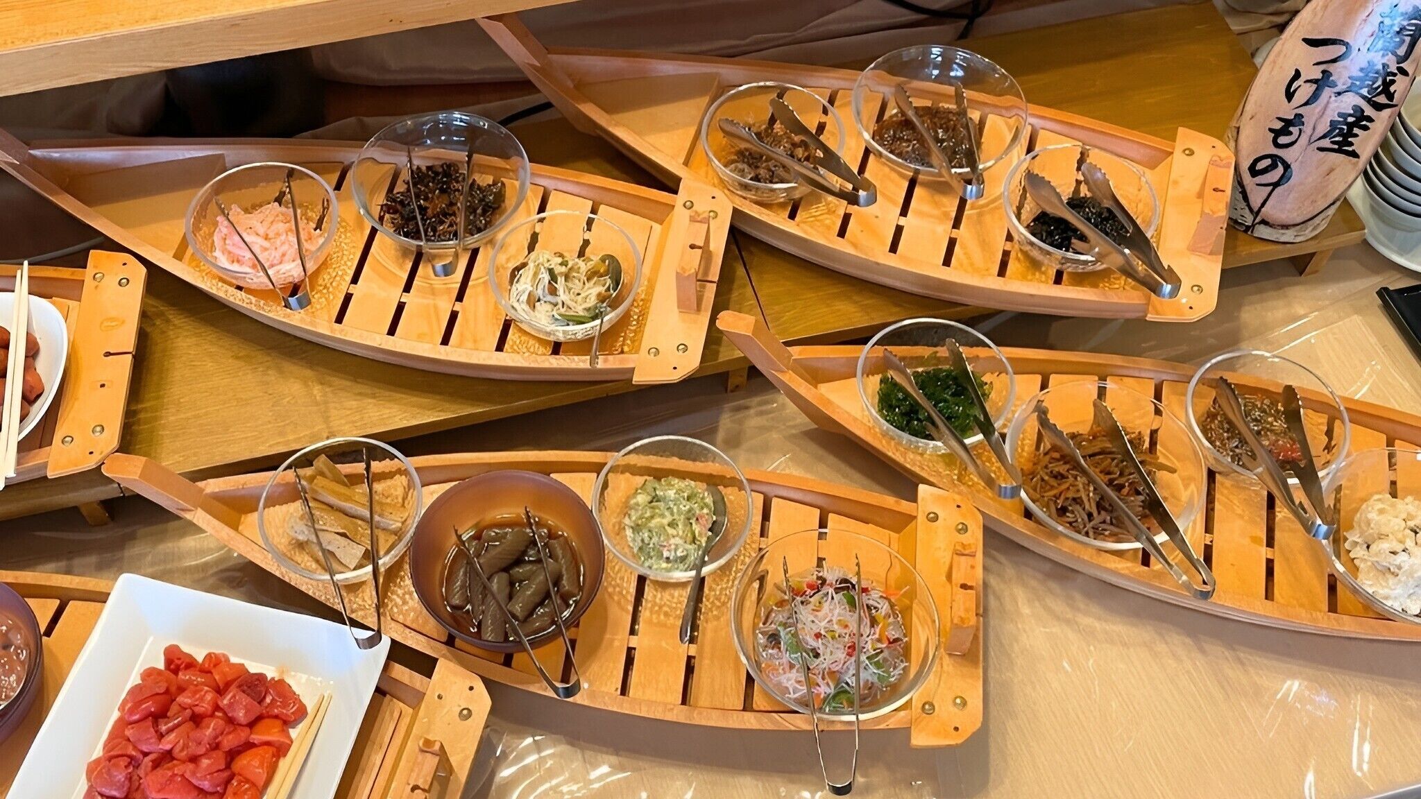 A dining table with multiple wooden trays holding various food items and utensils.