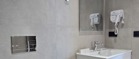Moderni kylpyhuone, jossa on wc, pesuallas ja peili.