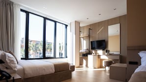 A modern hotel room with a large window, a bed, a desk, and a TV. - Koral Boutique Hotel & Bistro (Durrës)