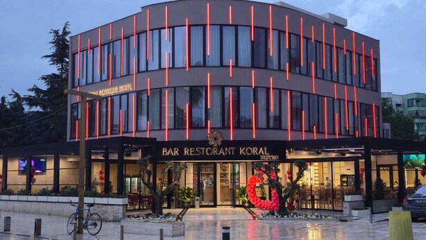 A modern hotel with a curved facade, large windows, and a prominent entrance. - Koral Boutique Hotel & Bistro (Durrës)