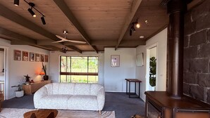 A cozy living room with a sofa, a fireplace, and a ceiling fan. - Southern Grampians Lookout (Dunkeld)