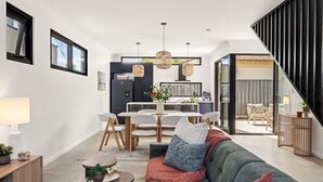 Un salon moderne avec un canapé, une table basse et un coin repas.
