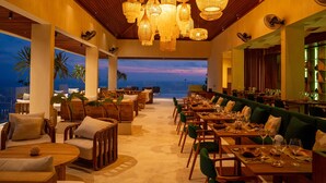 A restaurant with outdoor seating, wooden furniture, and hanging wicker chandeliers. - VANARA Resort & Spa (Pecatu)