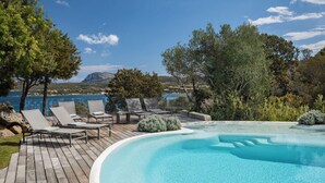 Una piscina con lettini e vista sul mare.