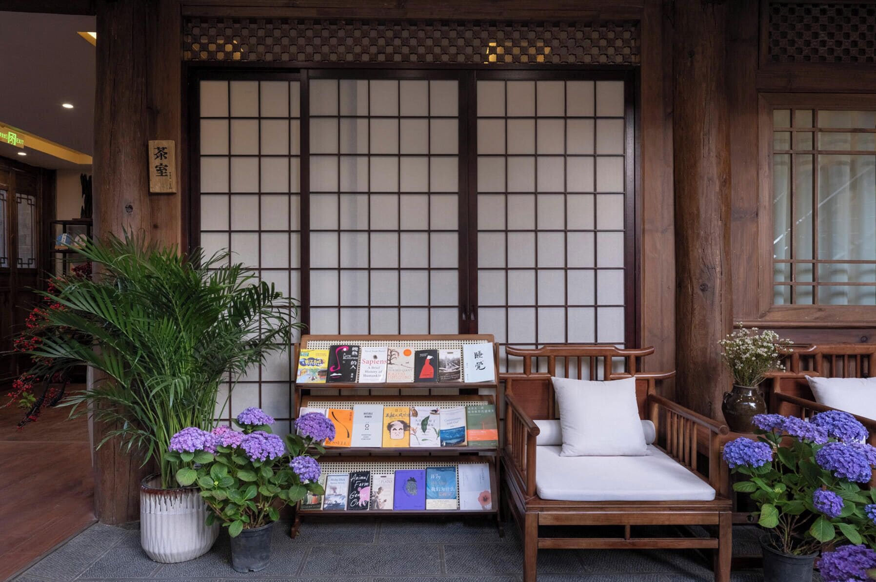 A traditional Japanese-style room with tatami flooring, a low wooden table with books, and a cushioned bench.
