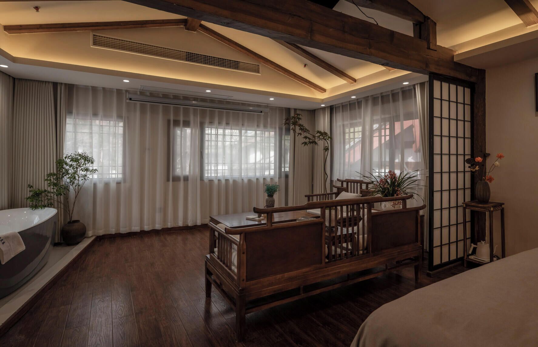 Ein Zimmer mit einer Holzbänkl, einer Badewanne und einem traditionellen japanischen Bildschirm.