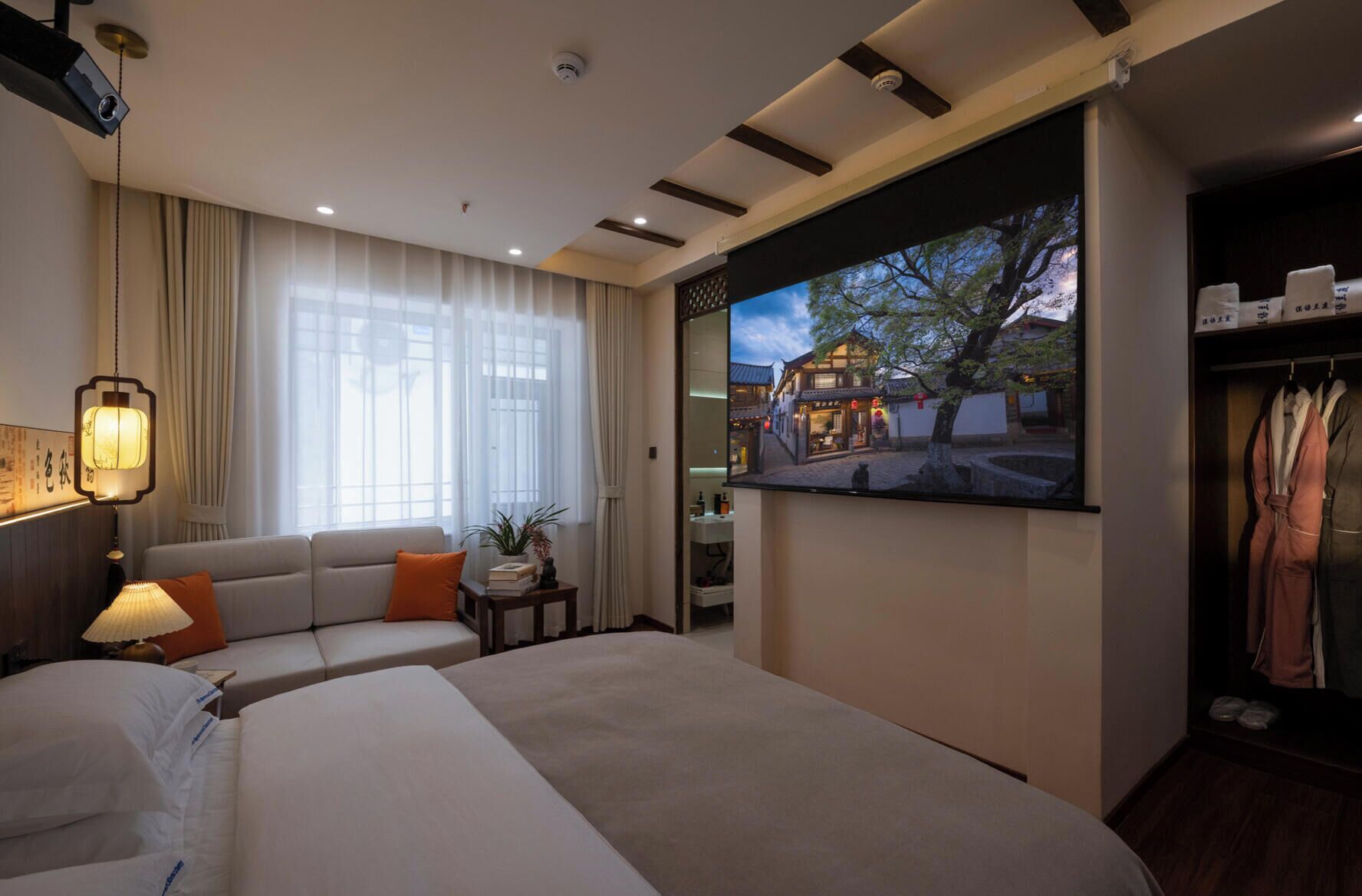 Una habitación de hotel con cama, sofá, televisor, escritorio y armario.