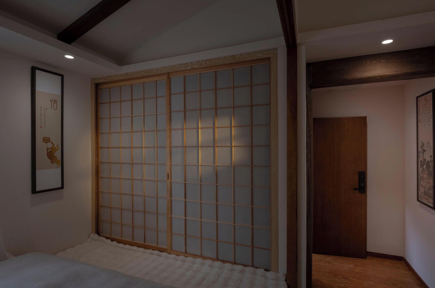 A room with a sliding shoji screen door, a framed artwork on the wall, and a wooden door leading to another room.