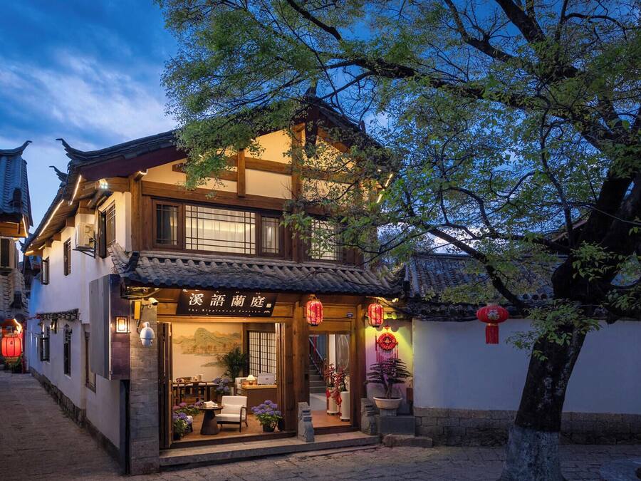 A traditional building with a sign in a foreign language, a wooden door, and a window.