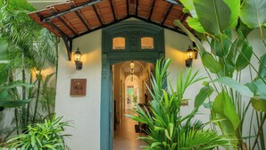 A building with a green archway, a wooden roof, and a sign that reads 'Villa C.' - ELIVAAS Monforte Ayada 3 BHK Villa (Assagao)