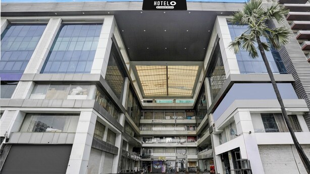 Ein Hotel mit moderner Architektur, das ein zentrales Atrium, mehrere Etagen und eine große 'HOTEL'-Beschriftung zeigt.