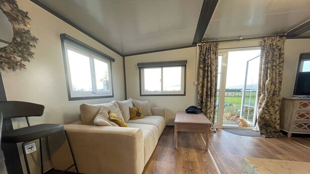 Un espacio de sala acogedor con un sofá, una mesita y un mueble para la televisión.