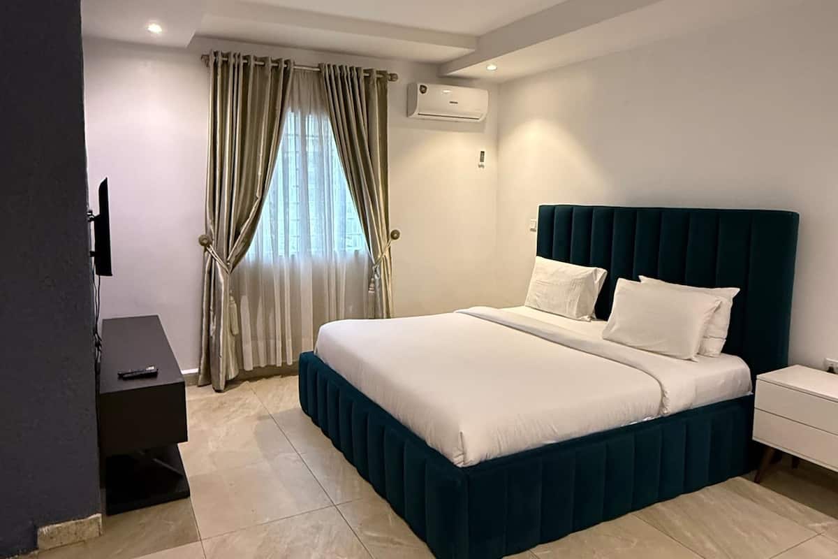 Une chambre d’hôtel moderne équipée d’un lit, de tables de chevet, d’un climatiseur et d’un téléviseur.