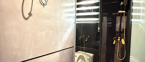 Un bagno moderno con doccia vetrata, un water e un lavandino con specchio.