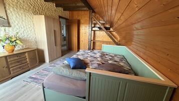 A room with a bed, a dresser, and a wooden wall.