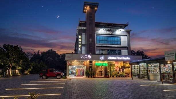 A hotel with a 'HOTEL' sign, a 'PURE VEG' restaurant, and an 'AIITHI COMFORTS' store. - ATITHI COMFORTS (Somvarpet)