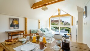 A breakfast setup with a wooden table, breakfast items, a painting, and a view of the outside. - Guest Room 'Auguste' with Shared Pool (Plobsheim)