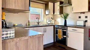 A modern kitchen with a built-in oven, a sink, and a window providing natural light.