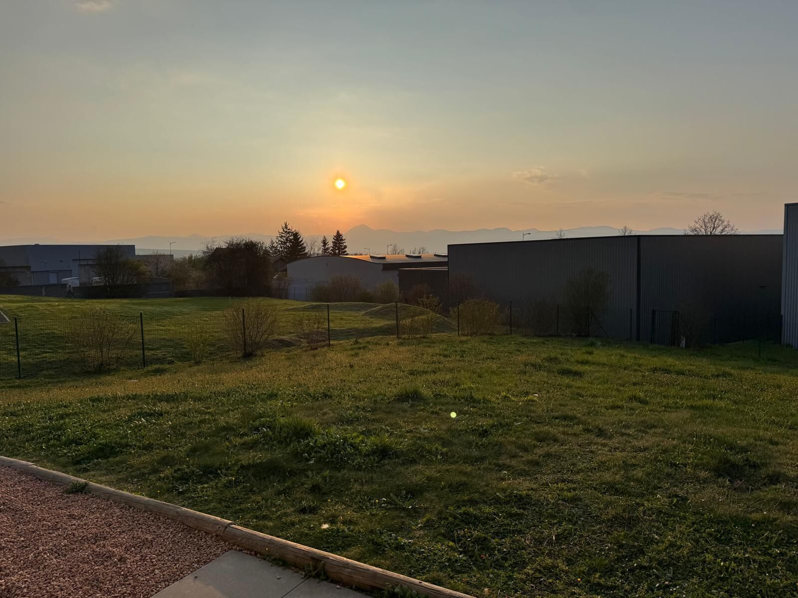 Un prato erboso con un edificio sullo sfondo.