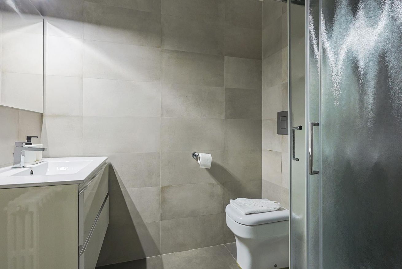 Une salle de bain comprenant des toilettes, un lavabo et un espace douche.