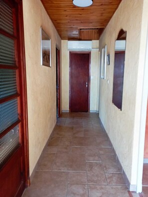 A hallway with a wooden ceiling, tiled floor, and a closed door at the end. - NEW 2026: House 3*Nature Calm Space view on the Rock center of SAMPZON (Sampzon)