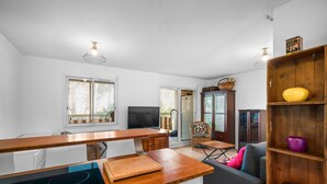 A modern kitchen with a built-in stove, wooden countertop, and a dining area with a table and chairs. - Beautiful 2-Bedroom Apartment in Green Estate with Shared Pool, Balcony & Wi-Fi (Six-Fours-les-Plages)