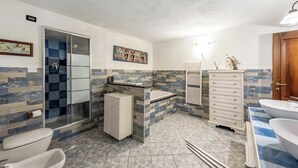 A bathroom with a shower, toilet, sink, and storage cabinet. - Genova House Via Caffaro (Genoa)