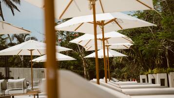 A row of white lounge chairs and umbrellas, suggesting a resort setting.
