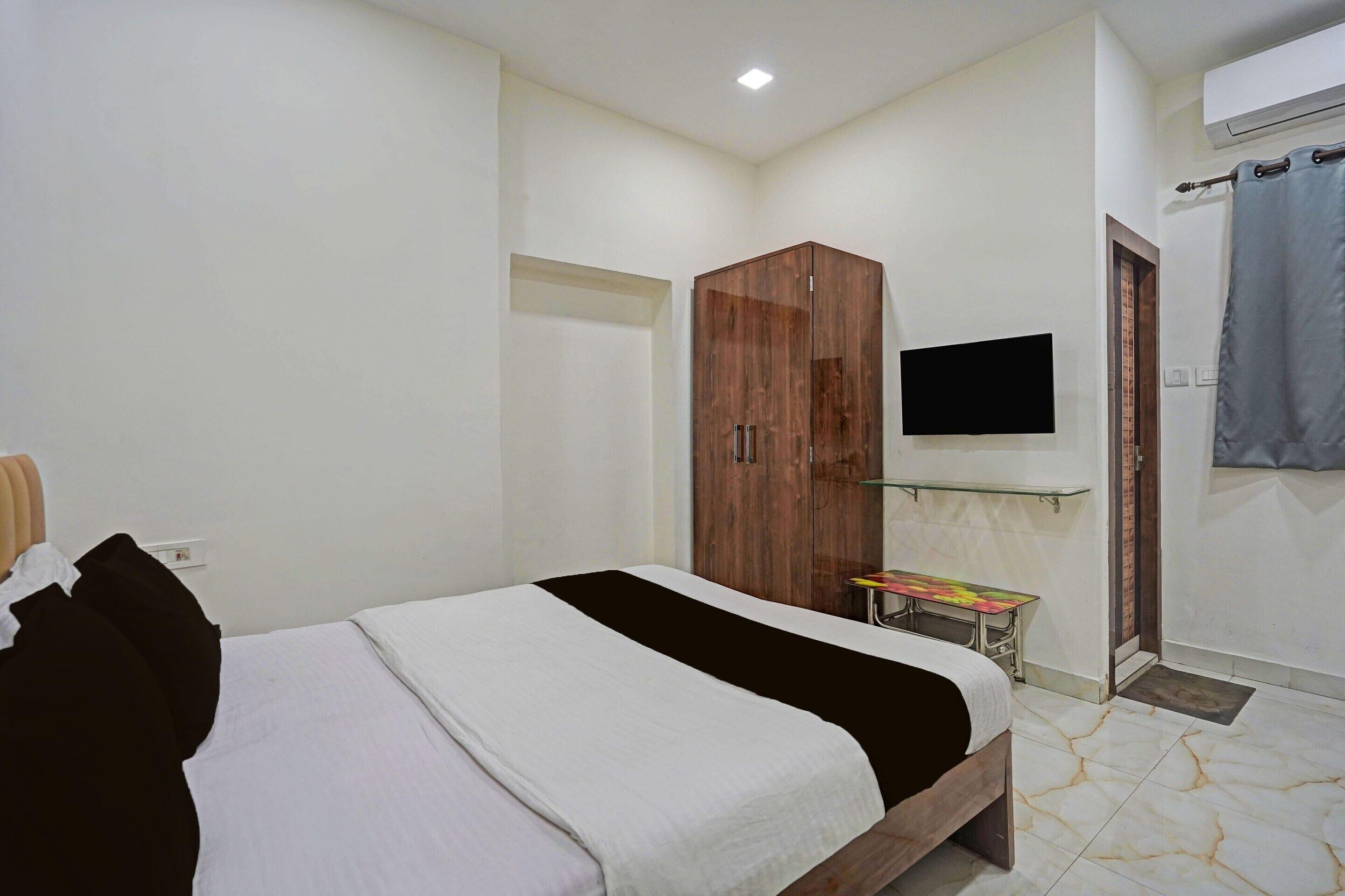 Una camera da letto con un letto, un armadio, una TV e un piccolo tavolo.