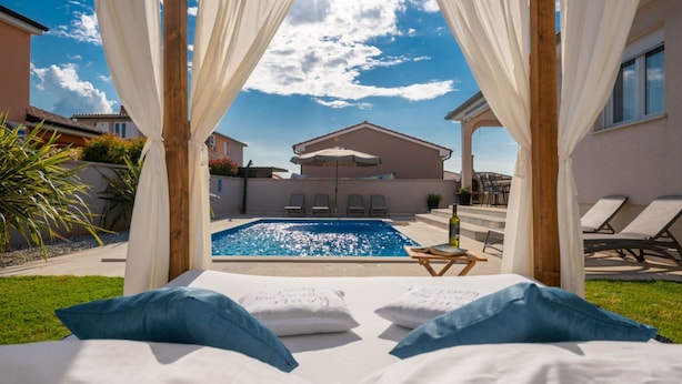 A poolside bedroom with a view of a swimming pool, outdoor seating, and a covered patio area. - Villa Greta - Jadreški by Villas Guide (Jadreški)