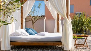 A bed with white bedding and blue pillows, a wooden frame, and white curtains. - Villa Greta - Jadreški by Villas Guide (Jadreški)