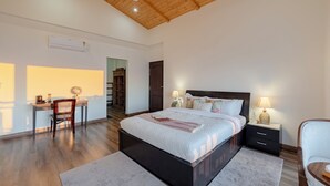 Une chambre à coucher comprenant un lit, des tables de chevet, un bureau et une chaise.